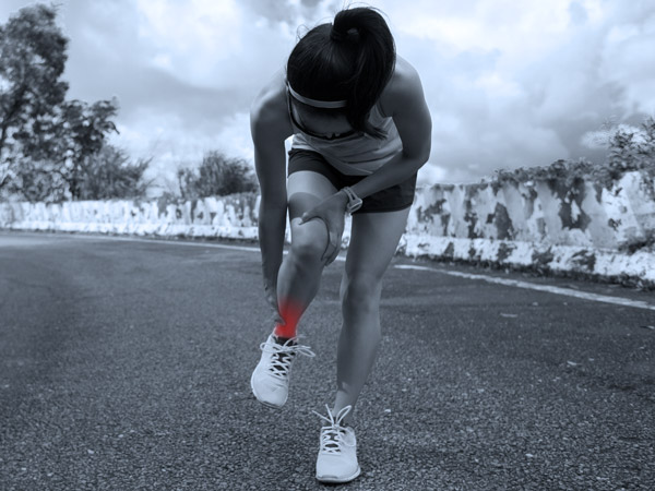 Image of a young female runner holding her ankle